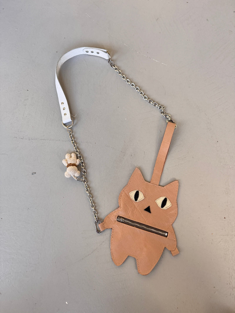 Metallic fat cat-shaped pouch with a chain on a gray background