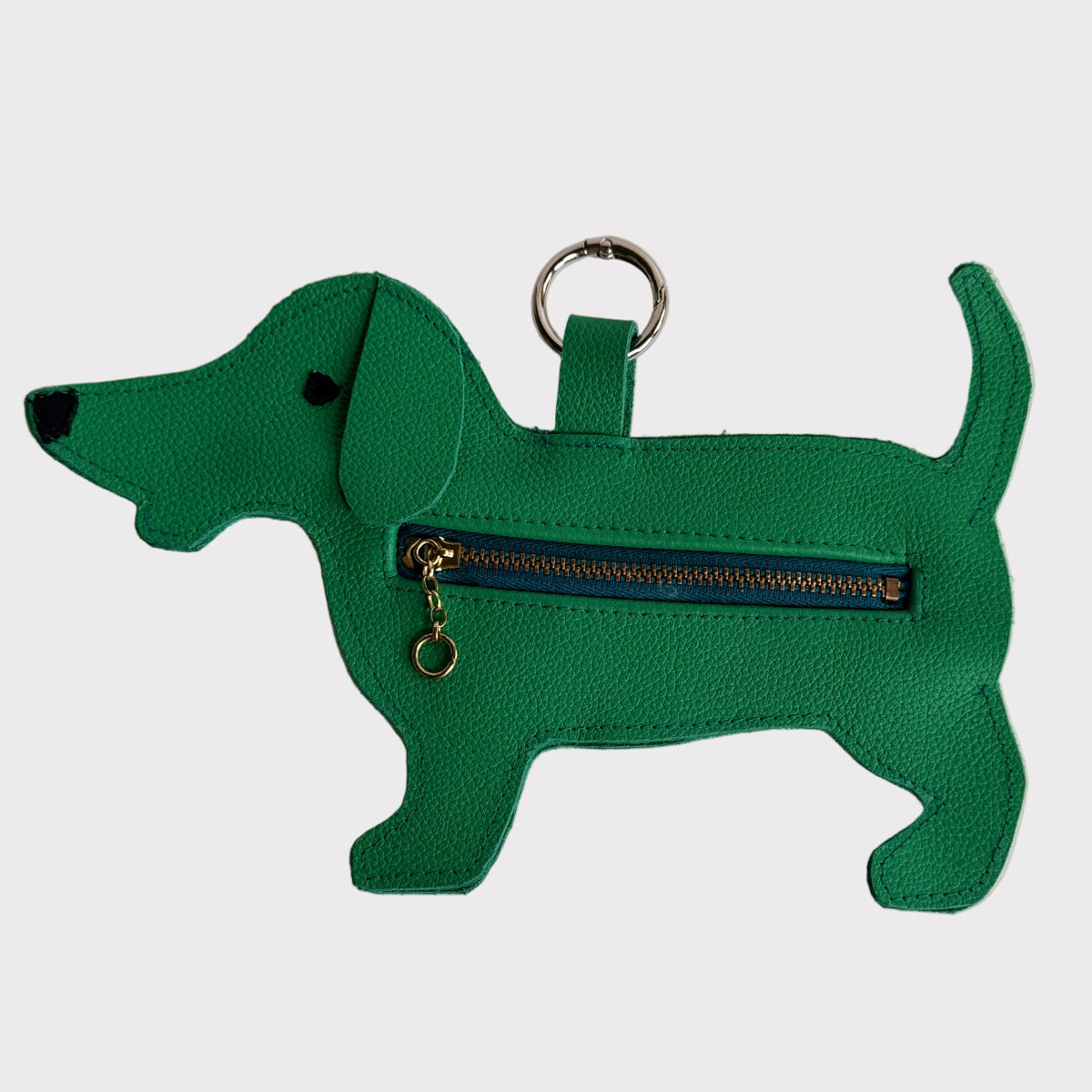 Green dog-shaped dog-poop-bag-dispenser with a zipper on a light gray background