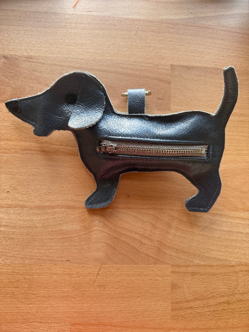 Black leather product with a zipper on a wooden surface