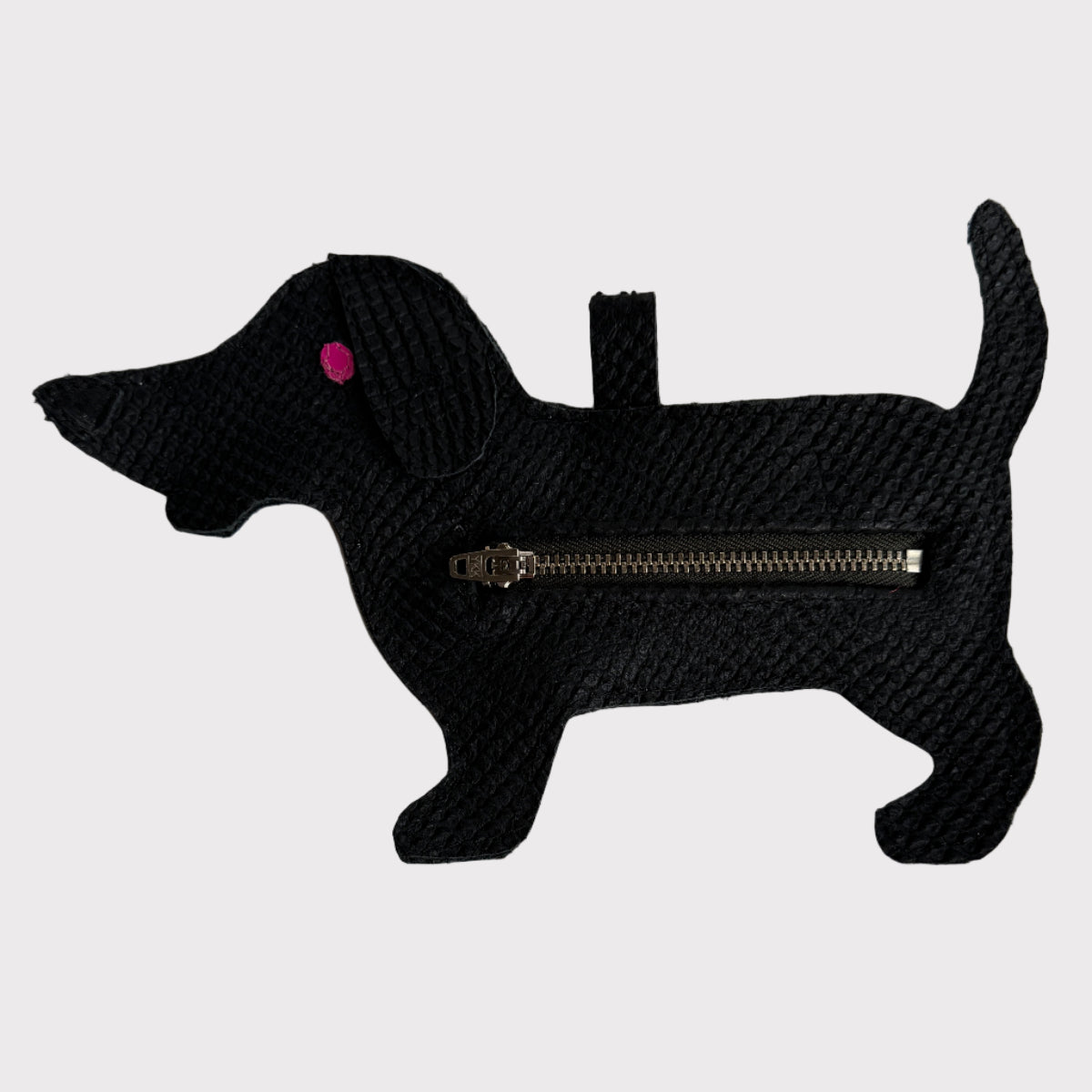 Black dog-shaped poop-bag-holder with a zipper on a light gray background