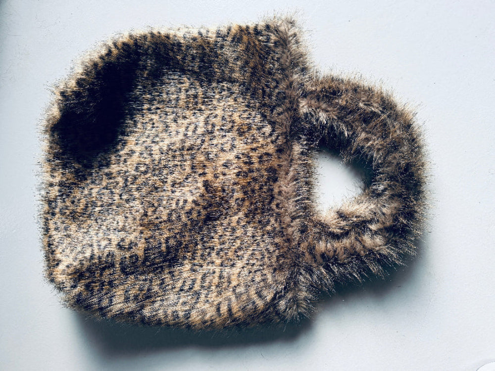 A fluffy, leopard print tote bag and dog bed in one