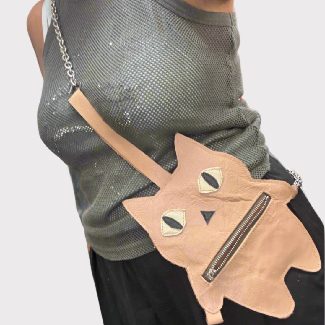 Person wearing a cat-shaped bag with a neutral background