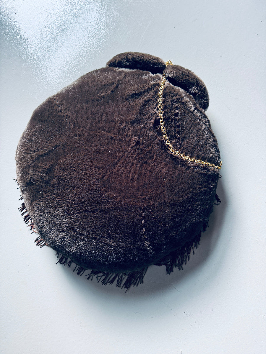 A fluffy round shoulder bag /computer backpack and dog bed for entrepreneur dog parents who work at cafes 