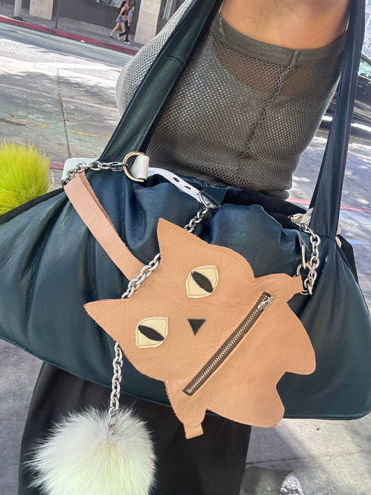 Pouch with cat design and chain strap held by a person