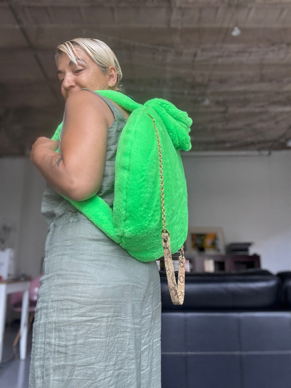 A woman is wearing a Muse et Moi Bark Bed Pro Backpack in neon green. 
