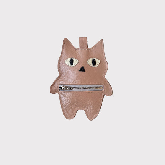Beige leather bag-charm with zipper on a gray background