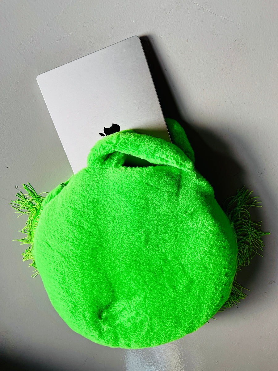 A dog bed/computer bag in one, round with fringes and 
